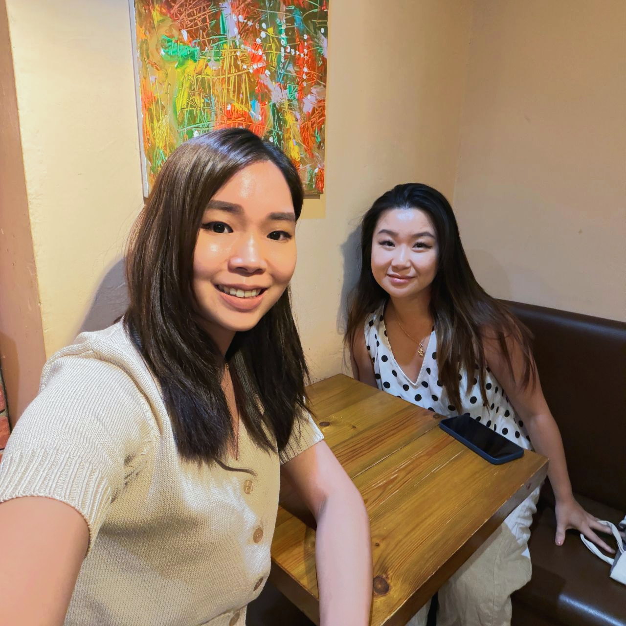 Jing and Sharon seated together at a restaurant table.